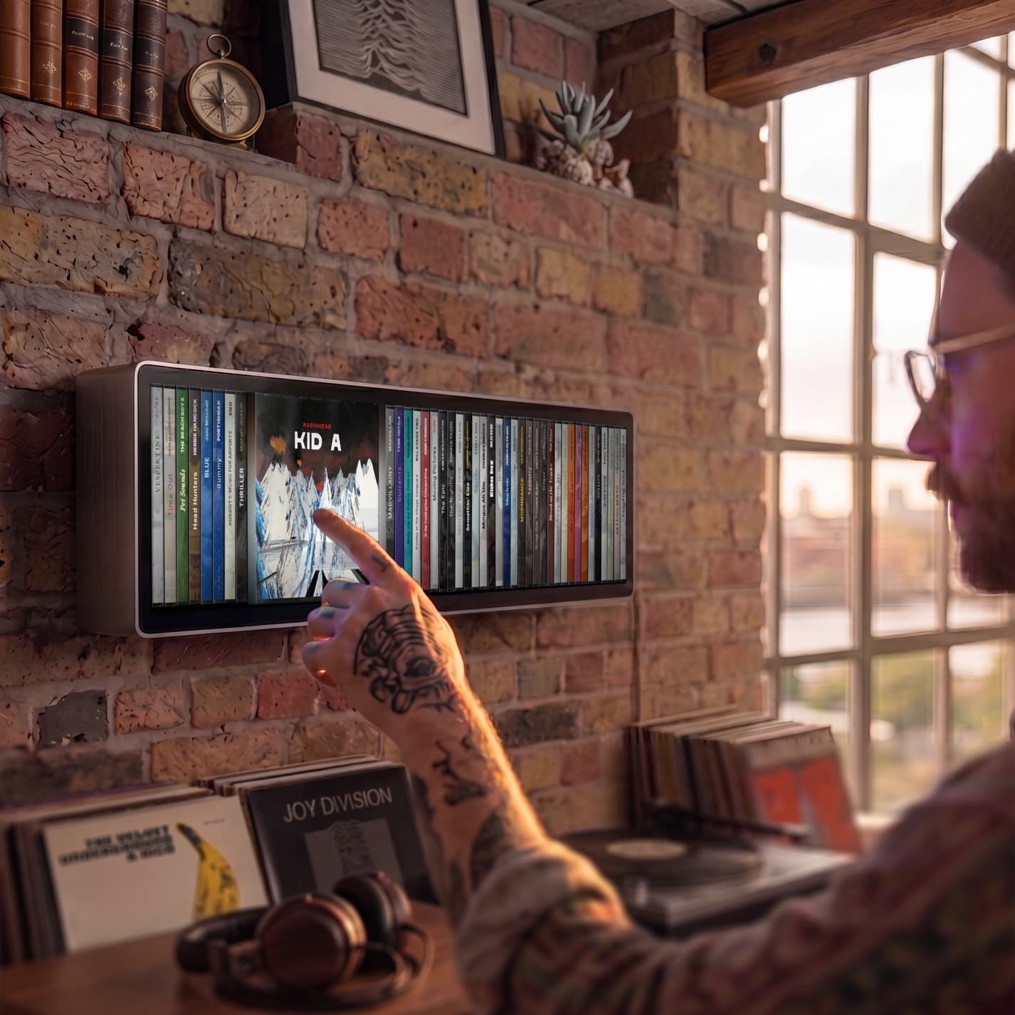 Spine mounted on an exposed brick wall in a London loft, with a vinyl collection and turntable below and the city skyline through a warehouse window. CGI render, not final product.